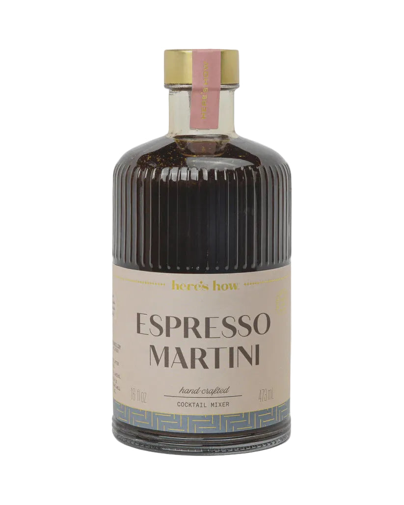 A bottle of Espresso Martini cocktail mixer by here's how, featuring a dark brown liquid in a ribbed glass bottle with a beige label and a gold cap, set against a light gray background.