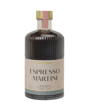 A bottle of Espresso Martini cocktail mixer by here's how, featuring a dark brown liquid in a ribbed glass bottle with a beige label and a gold cap, set against a light gray background.