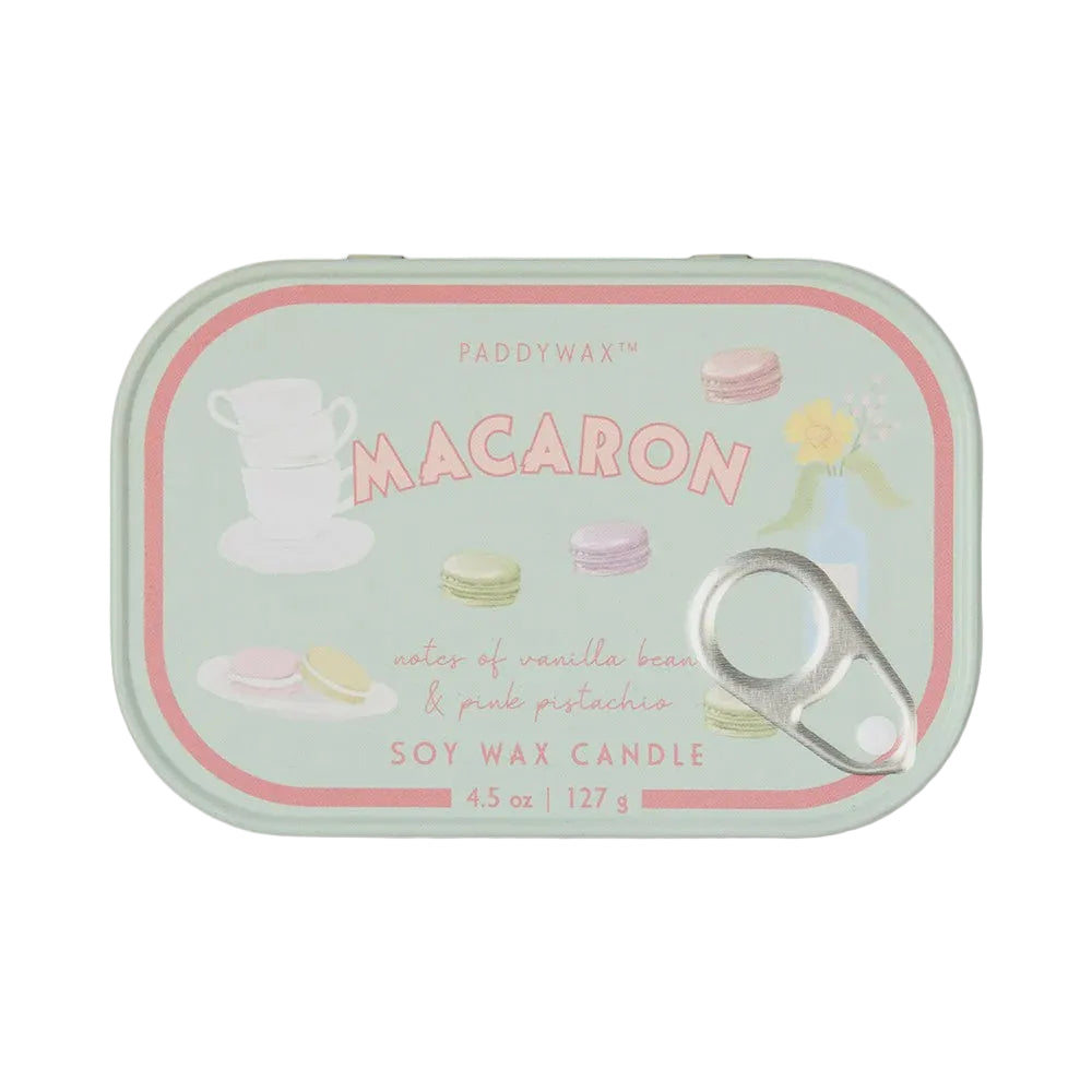 A Paddywax Macaron soy wax candle in a mint green tin with pink and pastel macaron illustrations and a silver pull tab, shown on a light gray background.